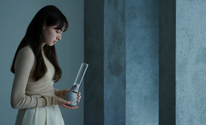 一位年輕女士手持 Sony LSPX-S3 玻璃揚聲器，展示此產品的便攜性。